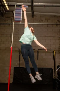 Athlete performing a vertical jump assessment in a sports performance gym